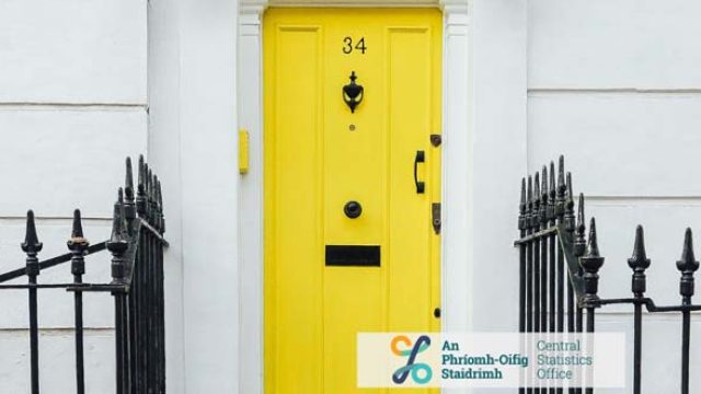 Bright yellow door with number 34, framed by a black iron fence and white walls, showcasing a welcoming entrance.